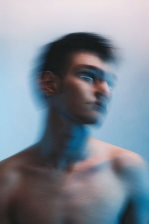 Blurry portrait of topless young man moving his head