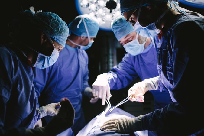 Professional surgeons performing surgery in operating room of a hospital
