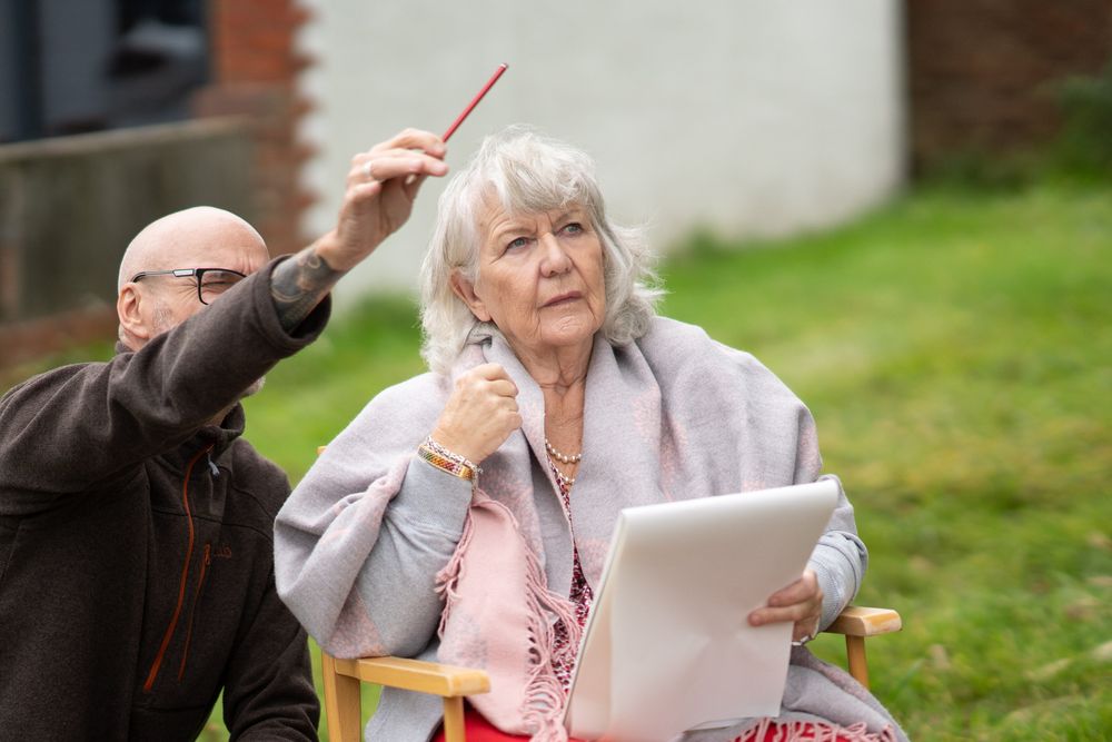 Woman receiving instruction during art class