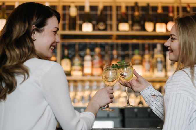 Cheerful woman drinking cocktails in bar