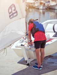 Male traveler with yacht near water