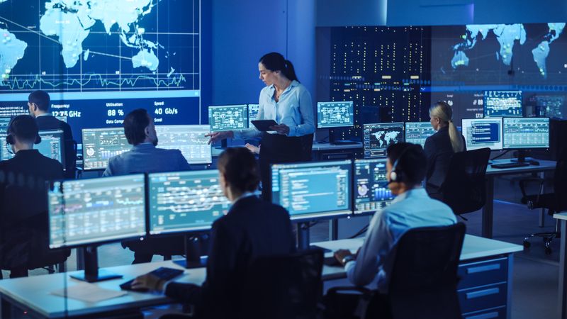 Female Supervisor Leads Team in Cybersecurity Command Center.