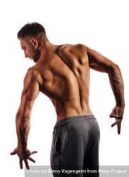 Bodybuilder’s back flexed practicing poses ahead of competition in light studio 5oL994