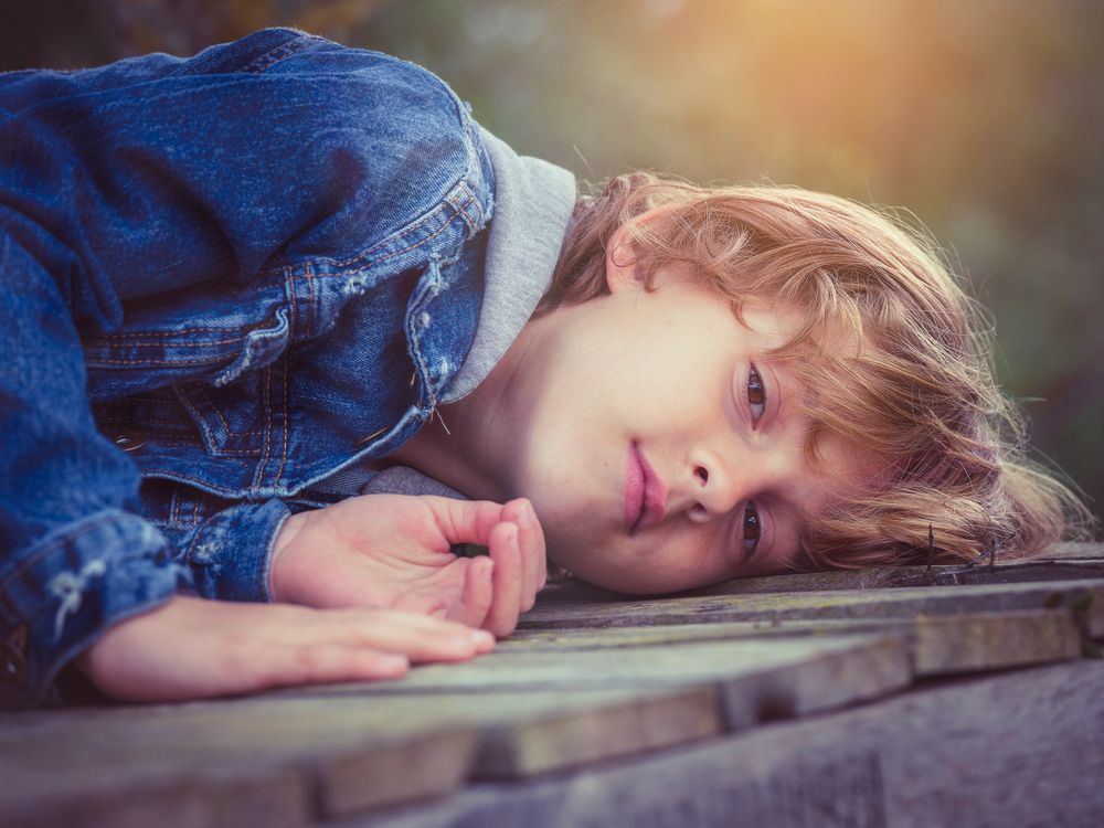 Boy lying on boardwalk and looking at camera