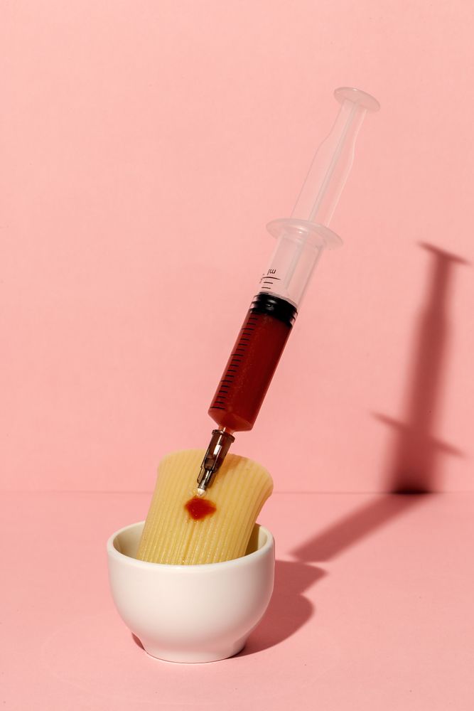 Stuffed pasta with red sauce in syringe