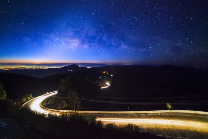 Milky way galaxy with stars and space dust in the universe and lighting on the road before morning at Doi inthanon Chiang mai, Thailand