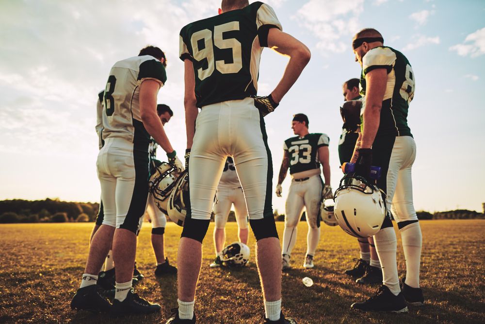 Team of football players talking on the field