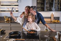 Happy multiethnic family taking selfie in kitchen