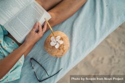 Close-up shot of woman reading a book with coconut drink 4mKgB0