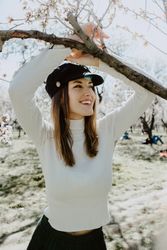 Young happy woman between trees in garden