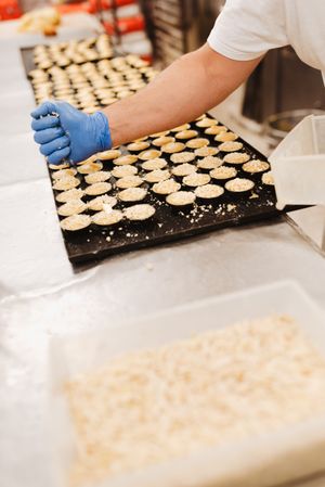 Crop baker squeezing dough on tray