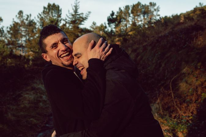 laughing men hugging in countryside road