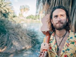 Hipster man in jungle with ukulele