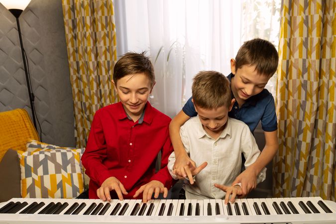 Three boys having fun at the piano