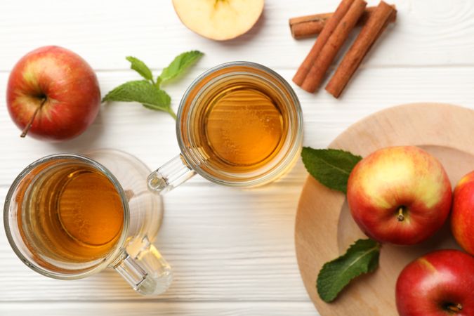 Composition with cider, cinnamon and apples on wooden background