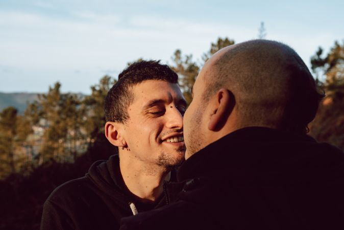 Smiling men hugging on countryside road