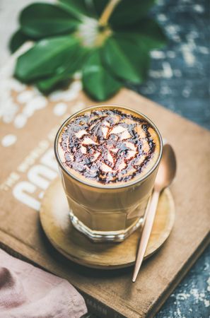 Top view of latte with decorative pattern in chocolate syrup on coffee bag