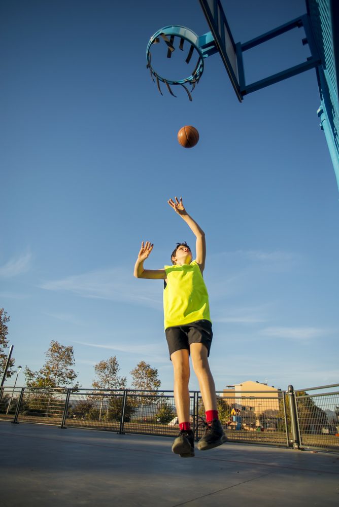 Basketball, teen shooting on basket , in action outdoors