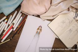 Fashion design sketches, dress materials and drawing pens on a table bDg1k4