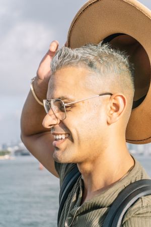 Side view of Young man with glasses. rising his hat