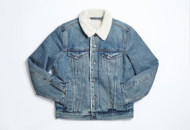 Denim jacket on light background, top view