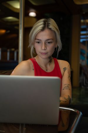 Woman in red tank top using computer