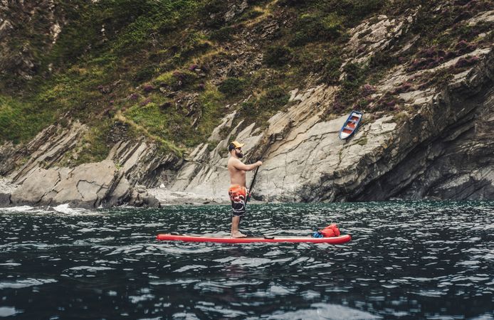 Man on paddleboard floating in sea
