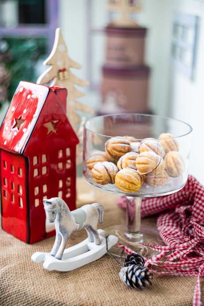 Holiday dessert concept with walnut shaped cookies stuffed with caramel cream surrounded by decorations