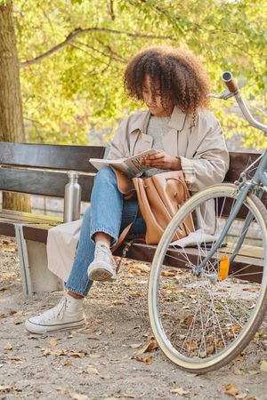 Black woman reading book in park