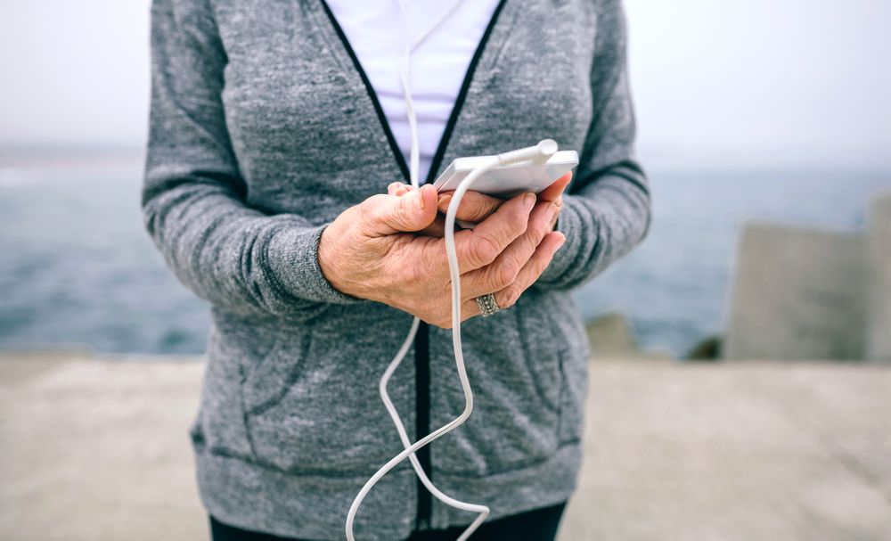 Mature sportswoman holding her smartphone