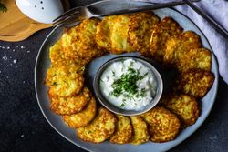 Top view of traditional Ukrainian dish deruny arranged on plate with dipping sauce