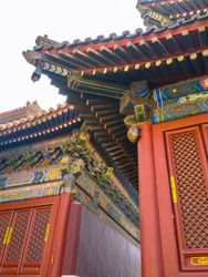 Close-up of ornate Chinese temple with intricate details, vibrant red and gold accents, and traditional wooden lattice doors