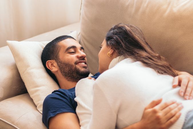Romantic stock photo of young couple on sofa at home