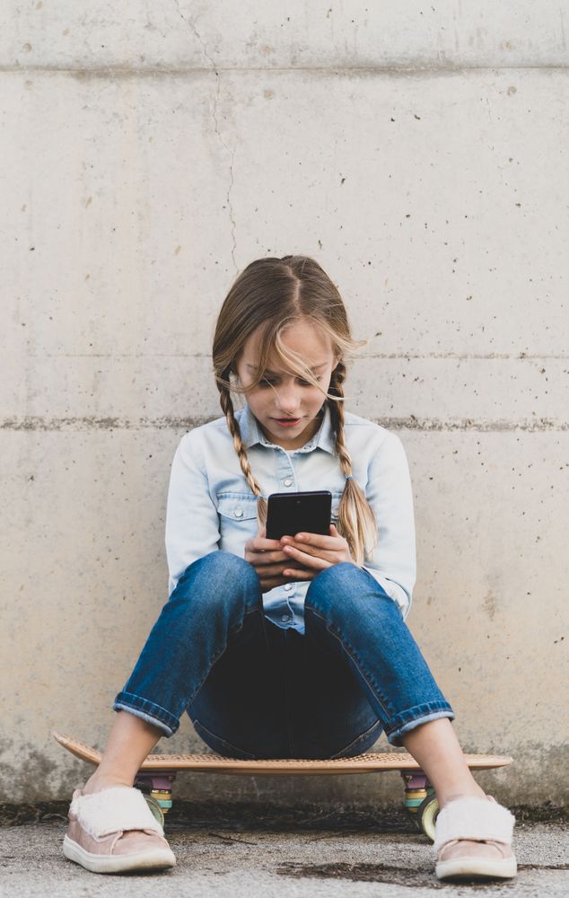 Kid using mobile phone with skate