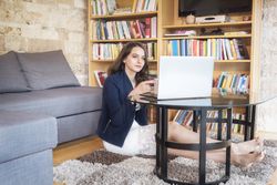 Smiling woman using a laptop at home