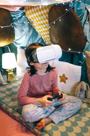 Portrait of child with VR headset watching augmented simulation on living room at home