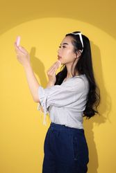 Young Woman Touch Her Make Up using Sponge Puff