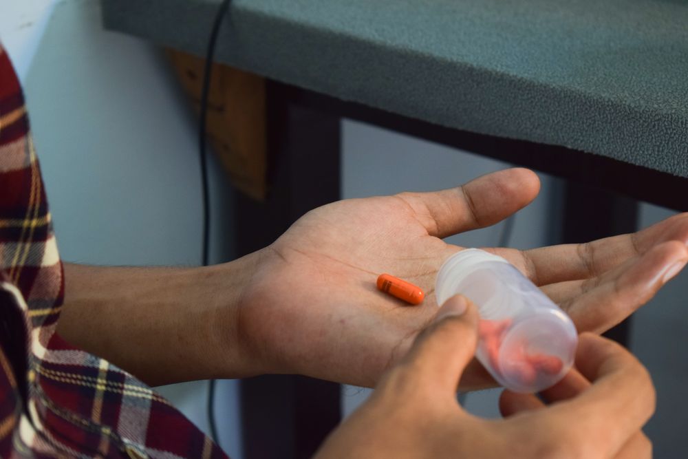 Hand of person with red pill in palm