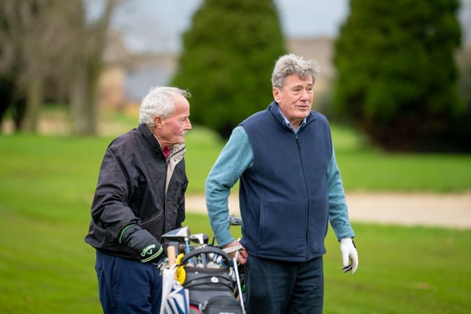 Two men walking on golf course with clubs