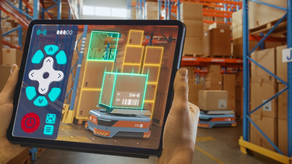 Future Technology Concept: Worker Holding Tablet With Remote Control AR Application For Automated Retail Warehouse AGV Robot with Infographics.