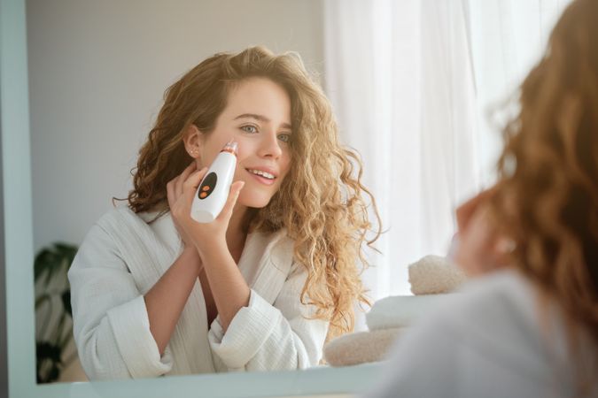 Woman using electric acne remover
