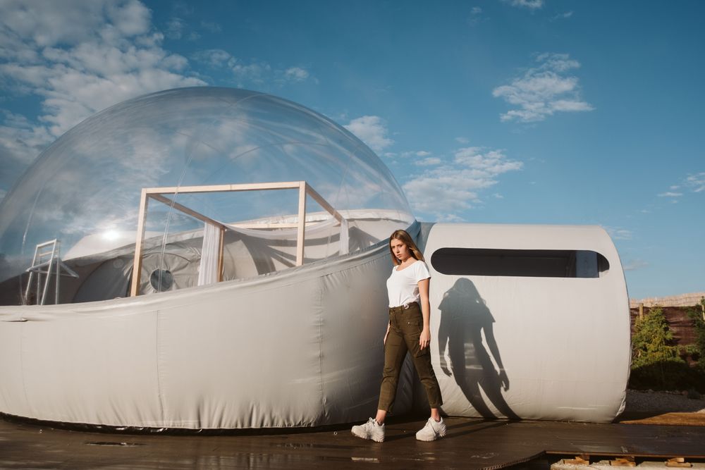 Stylish female standing near bubble hotel