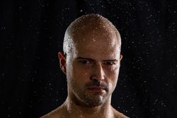 Serious bald man under rain