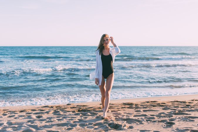 Woman in bathing suit standing by the ocean