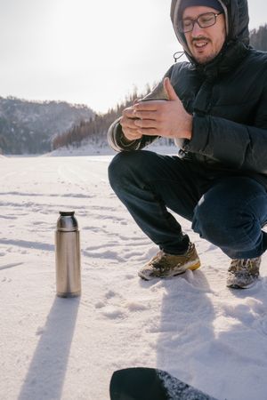 Traveler with enamel mug of tea on winter day