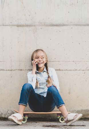 Kid using mobile phone with skate
