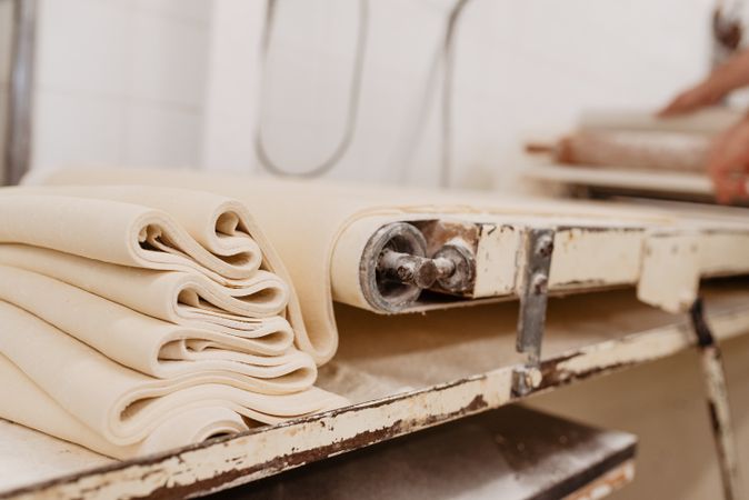 Professional machine rolling dough in bakery