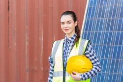 Woman in high visibility jacket holding a hard hard