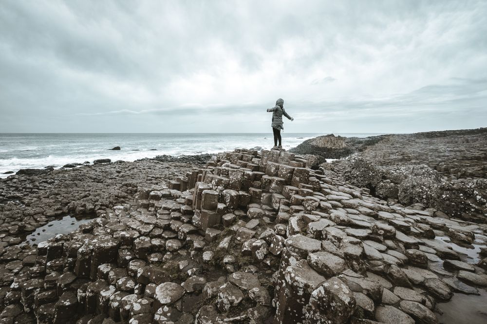 Female standing on cliff and contemplating