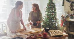 Portrait of Adult Woman Preparing Gingerbread for Christmas While her Older Mother is Helping.
